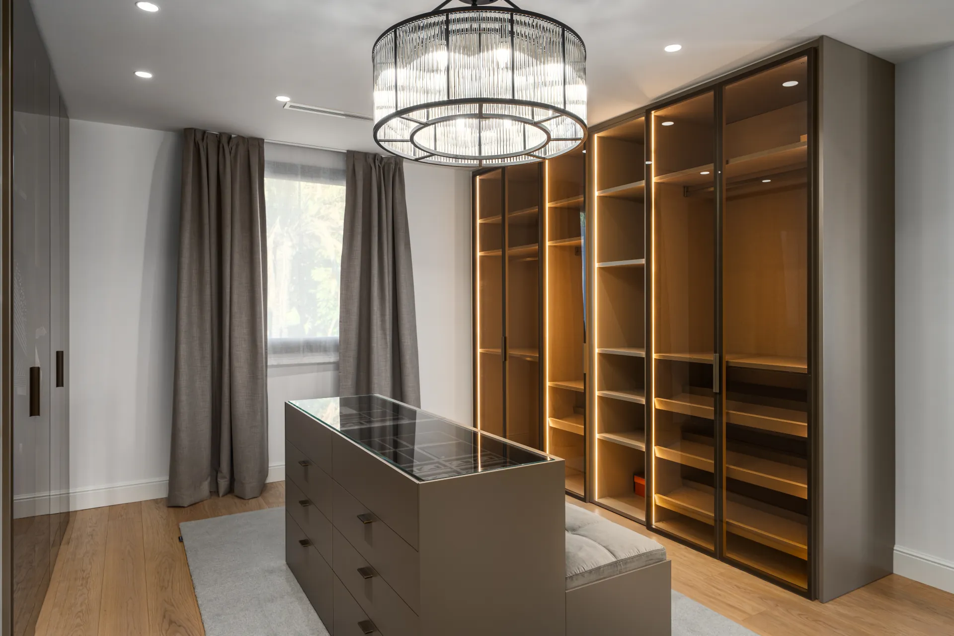 Dressing room as a jewel box. Crystal chandelier, glass‑top island, warm integrated lighting — designed digitally to feel as luxurious as a boutique hotel suite.